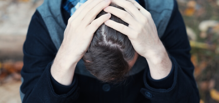 Man stressed with hands on head