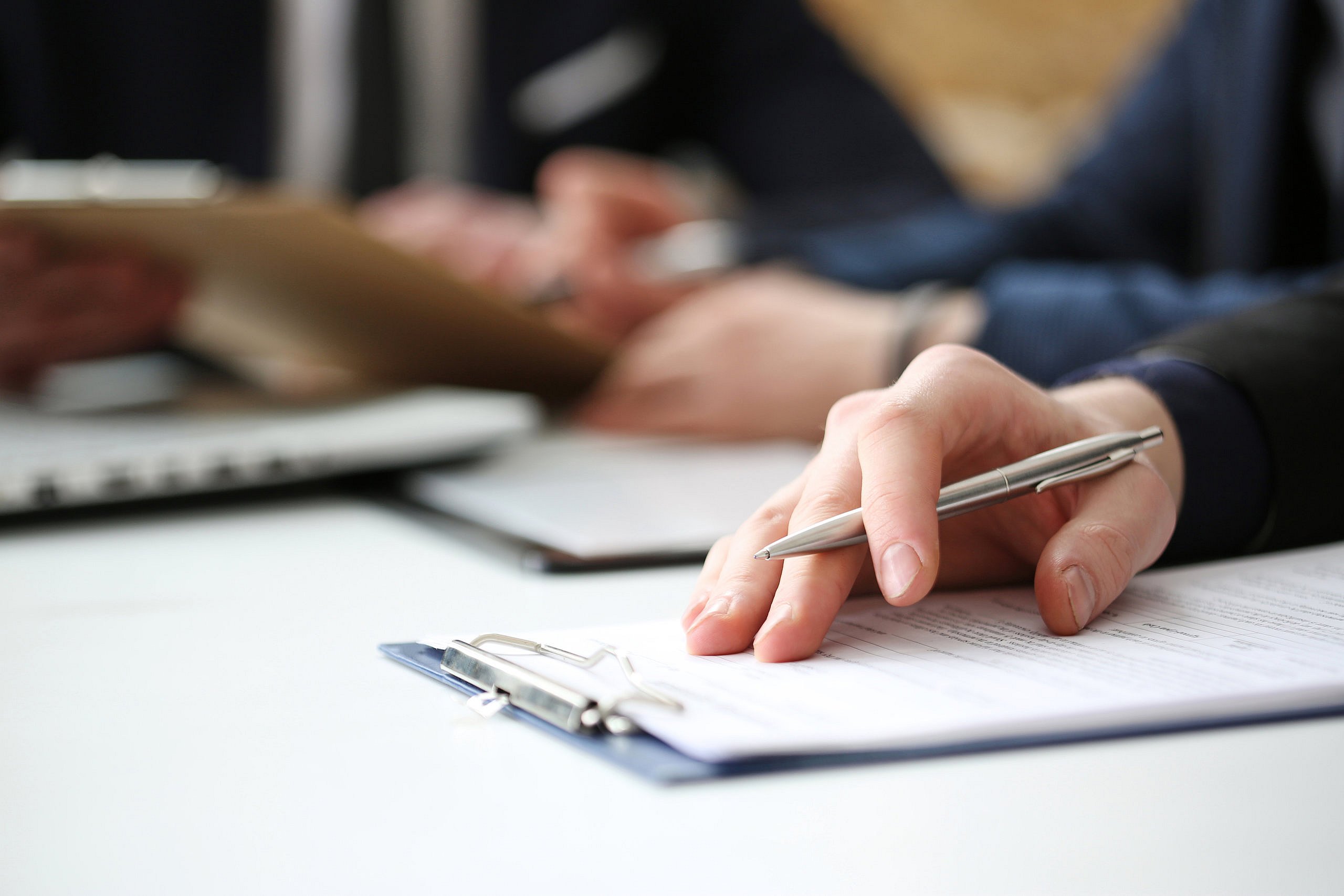 Close-up of hand on top of clipboard.