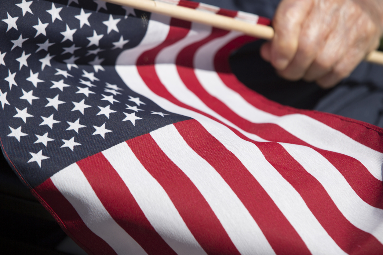 korean war veteran holding american flag