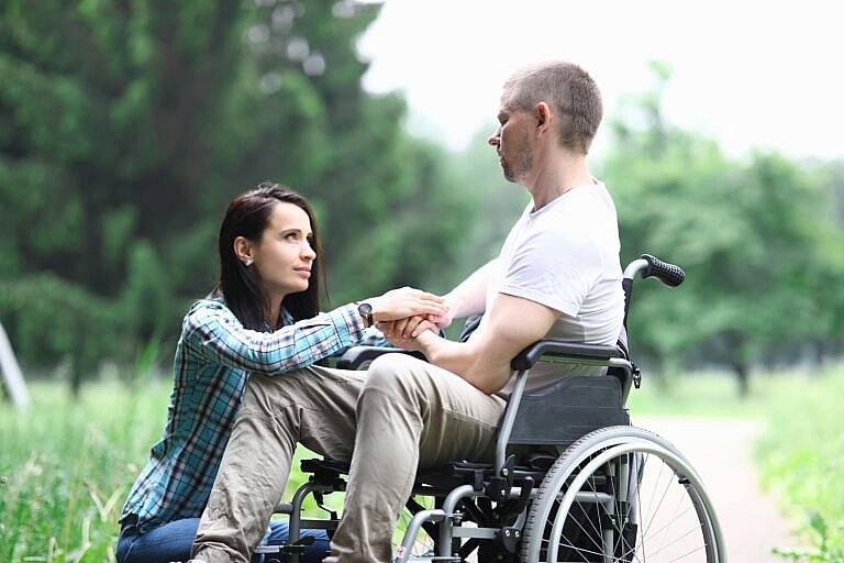 Family caregiver with man in wheelchair