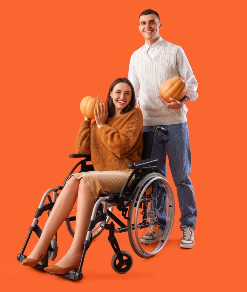 Halloween Survival Guide - disabled female with tall gentleman holding pumpkins.