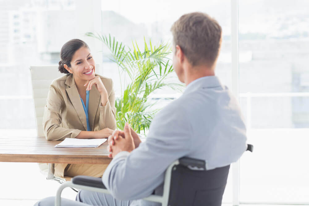 Smiling businesswoman interviewing disabled candidate