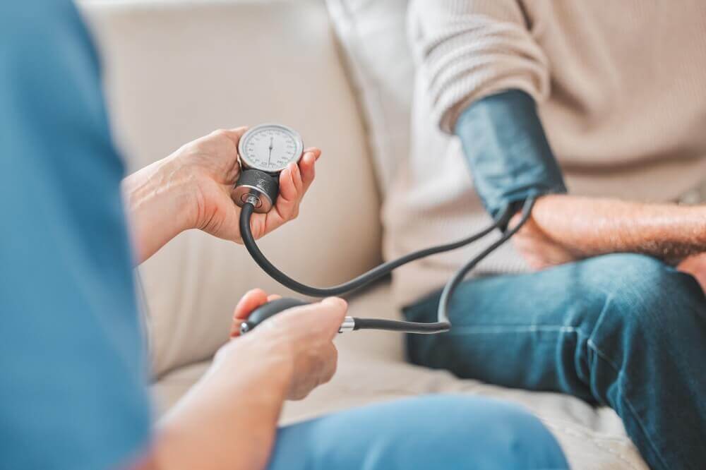 Nurse, elderly patient and blood pressure in house