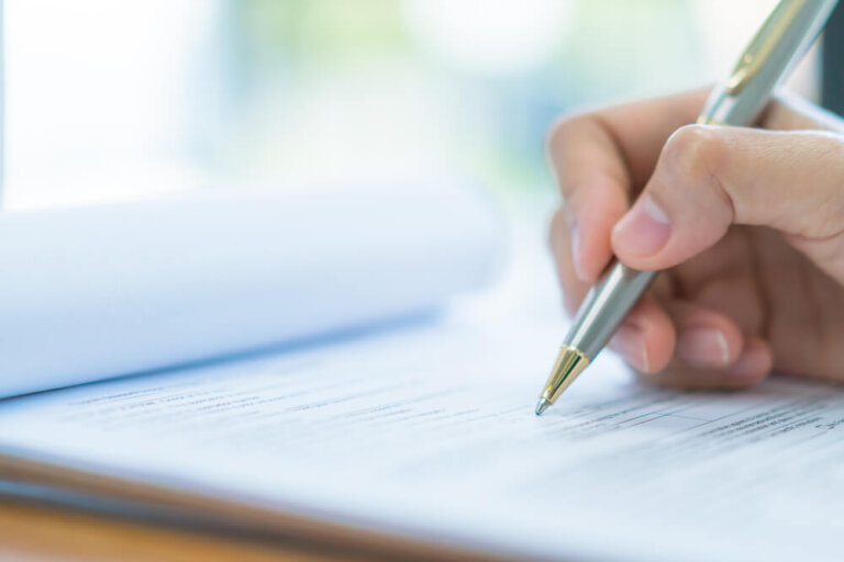Hand with pen over application form