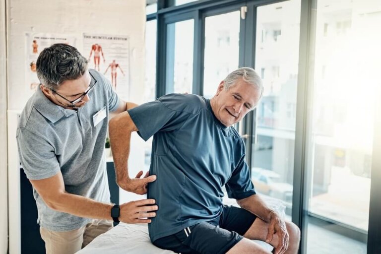 Physio therapist, chiropractor and senior man with back pain for rehabilitation, consulting and exercise.