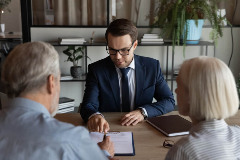Lawyer giving consultation to mature couple of clients, explaining legal documents