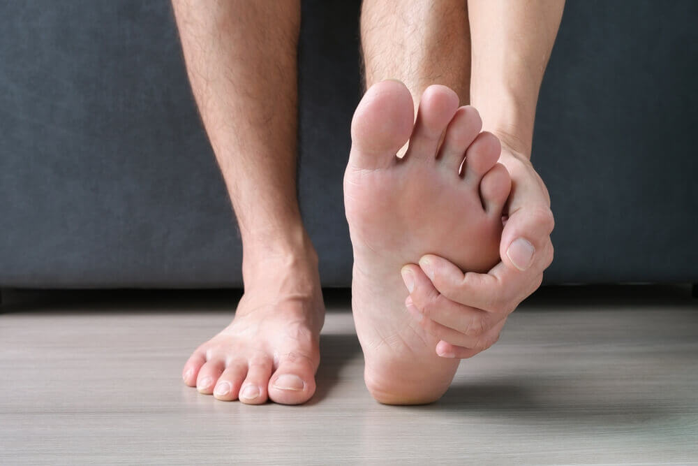 Man, foot pain and cramps in legs and ankles from Plantar Fasciitis disease Be relieved the pain with the soles of his feet.