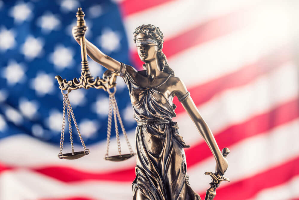 Lady Justice statue symbolizing fairness and veterans' benefits law with American flag background