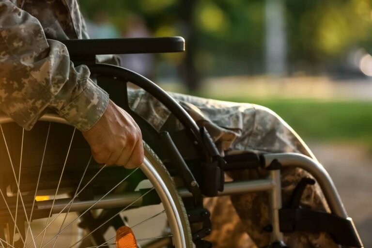 Veteran in camouflage uniform using a wheelchair, representing VA disability benefits and compensation rates for 2025.