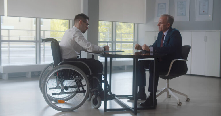 Disabled man in wheelchair meeting with disability lawyer to discuss SSDI or VA benefits claim