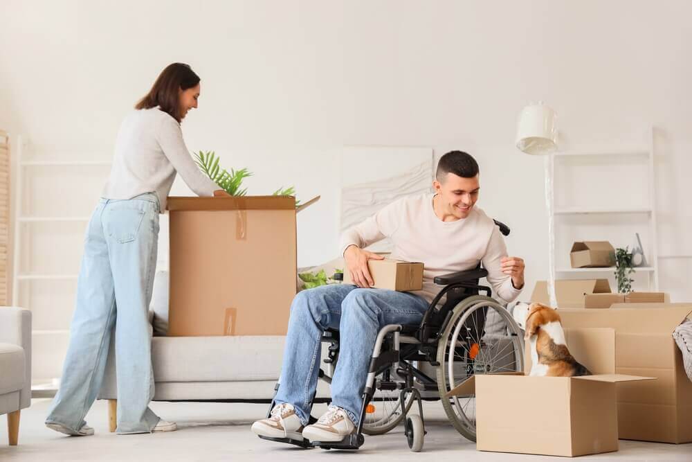 Man in wheelchair moving to a new home with partner and dog while receiving SSD benefits