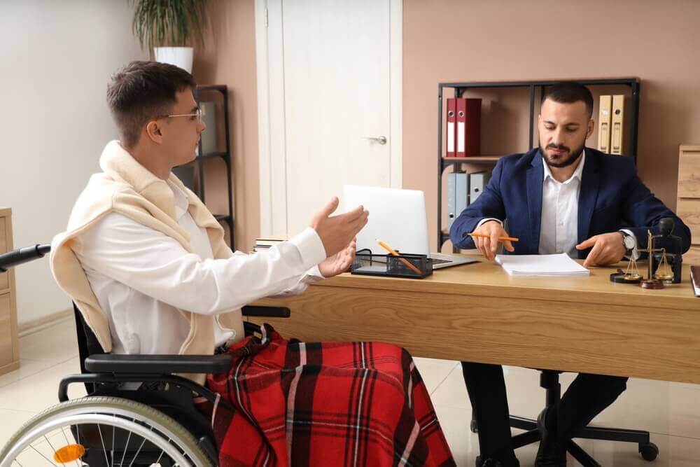 Disability Law Group attorney meeting with a client in a wheelchair to discuss a Social Security Disability claim.
