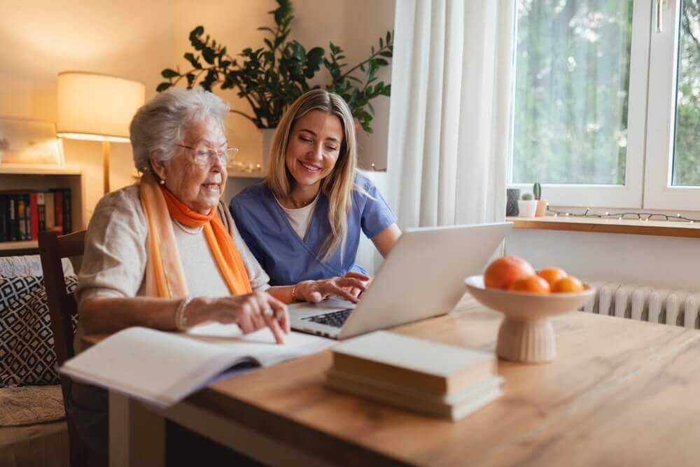 Social Security disability advocate helping an elderly widow review her Disabled Widow Benefits (DWB) application on a laptop.