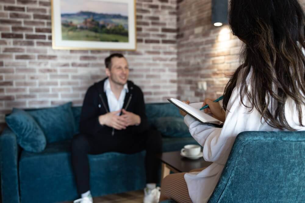 Man discussing mental health challenges with a therapist during evaluation for Social Security disability benefits.