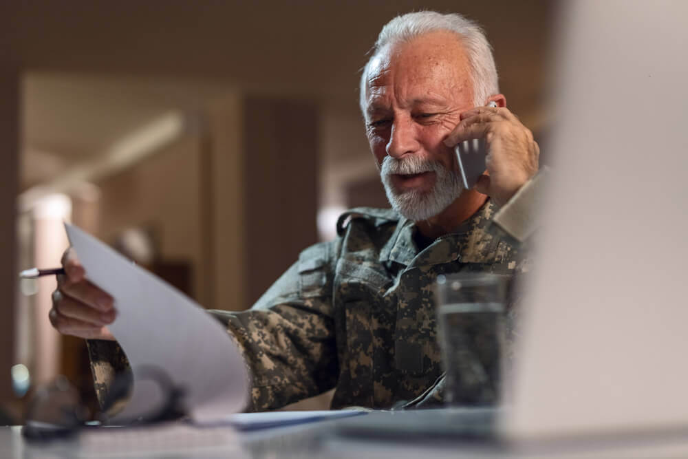 Veteran preparing for a VA disability C&P exam while speaking with a lawyer for claim guidance.