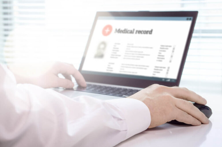 Reviewing medical records on a laptop for a Social Security disability claim evaluation.