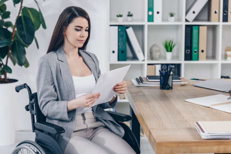 Woman in wheelchair reviewing SSI application paperwork at desk