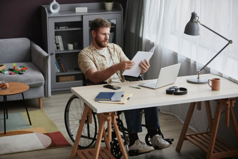 Man in wheelchair reviewing documents while working part-time during SSI application process
