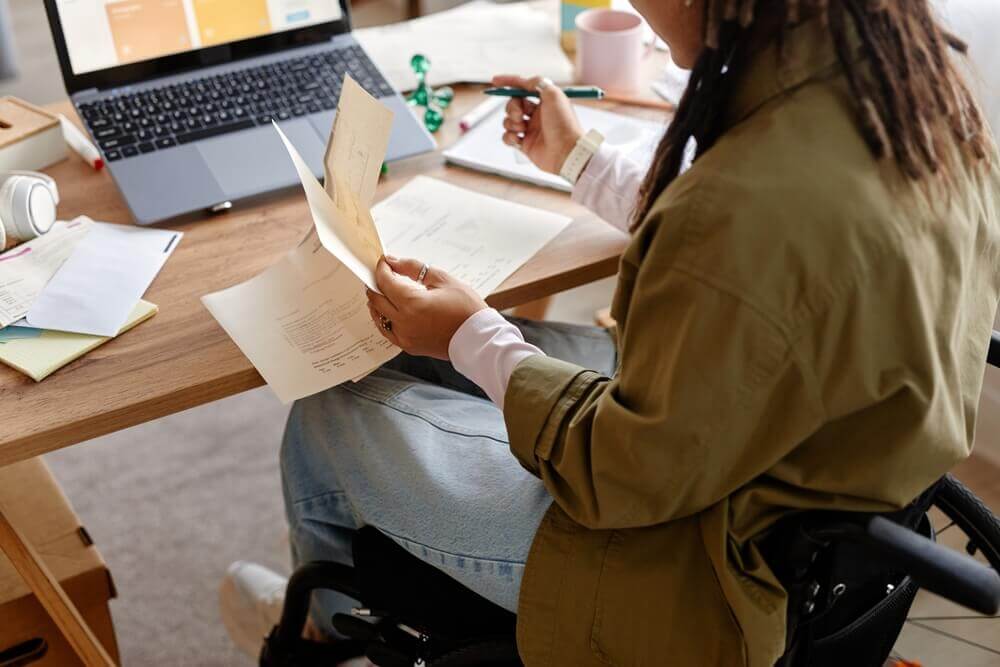 Person in wheelchair reviewing SSDI benefits paperwork